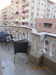 - un balcon avec des chaises et une table dans un bâtiment dans l'établissement شقة بالجيزة, au Caire