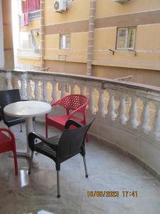 een balkon met stoelen, een tafel en een leuning bij شقة بالجيزة in Caïro