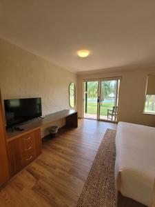 a bedroom with a bed and a flat screen tv at The Retreat at Wisemans in Wisemans Ferry