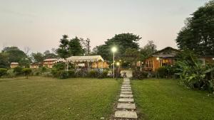 uma casa num campo com uma luz de rua e um quintal em River Park International Resort em Chitwan