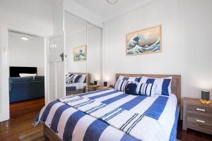 een slaapkamer met een bed met blauwe en witte strepen bij Seaview No 6 Henley Beach Wifi in Henley Beach South