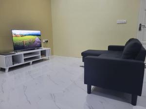 sala de estar con sofá y TV en Lavender seenu feydhoo addu city, en Feydhoo