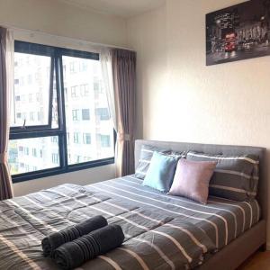 a bedroom with a large bed with a window at Escent condo Chiangmai F17 in Chiang Mai