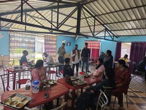 a group of people sitting at tables in a restaurant at Jayara Resort And Cafe in Barkot