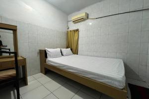 a small room with a bed and a mirror at OYO 93429 Pondok Surya in Pakato