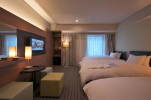 una camera d'albergo con due letti e una televisione di Prince Smart Inn Osaka Yodoyabashi ad Osaka