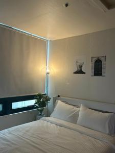 a bedroom with a white bed and a lamp at If House Hongdae in Seoul