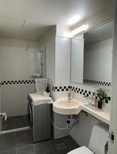 une salle de bain avec un lavabo, des toilettes et un miroir dans l'établissement If House Hongdae, à Séoul