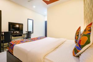 KolshetにあるFabHotel Sai Viharのベッドルーム(ベッド1台、デスク、テレビ付)