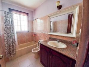 a bathroom with a sink and a toilet and a mirror at La Romana Vacation Home in Cumayasa Kilómetros 4 1/2