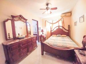 a bedroom with a bed with a dresser and a mirror at La Romana Vacation Home in Cumayasa Kilómetros 4 1/2