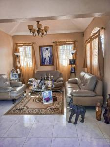a living room with couches and a table at La Romana Vacation Home in Cumayasa Kilómetros 4 1/2