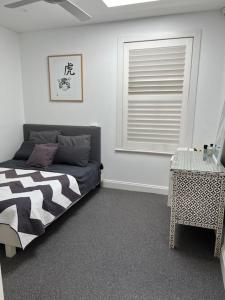um quarto com uma cama, uma janela e uma mesa em Modern Queens Park Home near Bondi Junction, Bondi Beach & City em Sydney