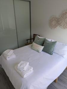 2 bedroom apartment with Garden views in Sydney في سيدني: سرير ابيض وعليه مناشف ومخدات