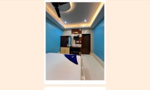 uma cozinha com paredes azuis e uma mesa branca num quarto em Hotel Holiday Home em Digha