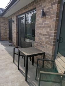 a wooden table and chairs on a patio at 2 bedroom apartment with Garden views in Sydney in Sydney