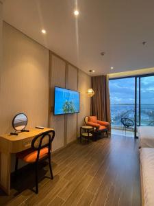 a hotel room with a desk and a tv at Queen Apec Mandala Phú Yên Condotel in Tuy Hoa +59 photos