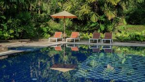 two chairs and an umbrella next to a swimming pool at Marina Express-Fisherman Aonang in Ao Nang Beach