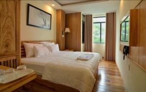 ein Hotelzimmer mit einem großen Bett und einem Fenster in der Unterkunft Senkotel Nha Trang Managed by NEST Group in Nha Trang