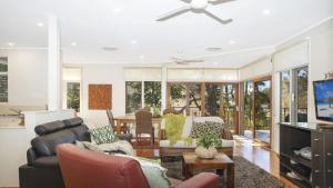 a living room with furniture and a ceiling fan at Waters Edge - Pet Friendly Holiday Home in Pearl Beach