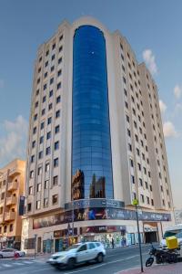 a large building with cars driving in front of it at Wescott Hotel in Dubai