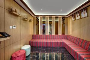 a red couch in a room with wooden walls at Wescott Hotel in Dubai