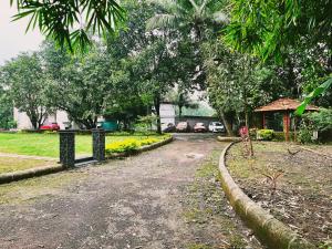 a dirt road in a park with trees and a house at NB Nature Stay in Navi Mumbai