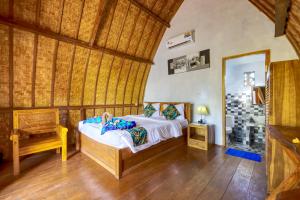 a bedroom with a bed and a chair in a room at Kira Cottages in Nusa Penida +44 photos