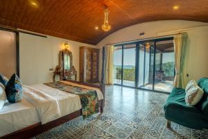 a bedroom with a bed and a balcony at Simroseate in Agonda