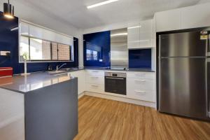 a large kitchen with a stainless steel refrigerator at Azure Beach Stop in South West Rocks