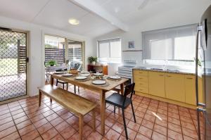 cocina con mesa y sillas en una habitación en Mandys Cottage - 7 Memorial Avenue South West Rocks, en South West Rocks