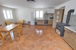a kitchen and dining room with a table and a stove at Jestřebí chalupa in Rtyně v Podkrkonoší
