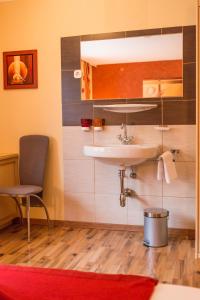 ein Badezimmer mit einem Waschbecken und einem Stuhl in der Unterkunft Alpinhome in Tux