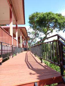 a wooden walkway next to a building with a tree at PawPaw Resort in Koh Samui