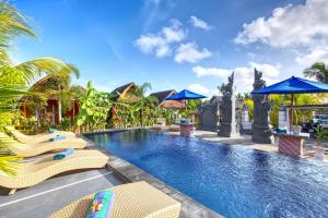 a resort swimming pool with chairs and umbrellas at Kira Cottages in Nusa Penida