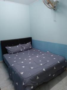 a bed in a room with a blue wall at Ipoh Rent Room 33 in Ipoh