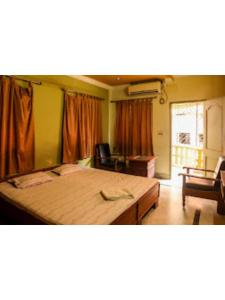 a bedroom with a large bed in a room at Roxy Inn,Cuttack in Cuttack