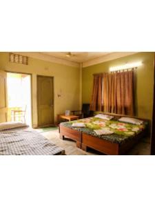 a bedroom with a bed and a table in it at Roxy Inn,Cuttack in Cuttack
