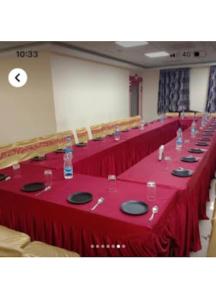 a row of tables with red table cloth and water bottles at Shri Jagannath Hotel,Cuttack in Cuttack