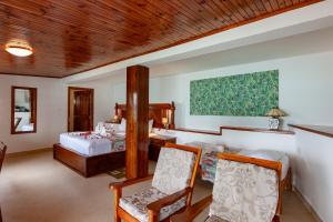 una camera da letto con un letto, un tavolo e delle sedie di Colibri Hotel a Baie Sainte Anne