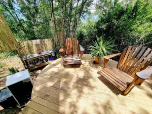 2 sillas de madera sentadas en una terraza de madera en Zen Valley Glamping en Plettenberg Bay