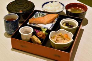 a lunch box with sushi and other foods and drinks at Asahikawa Sun Hotel in Asahikawa