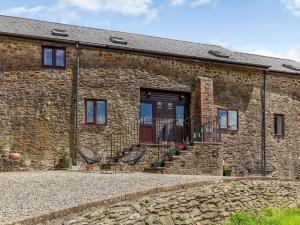 a brick building with two chairs in front of it at 3 Bed in South Molton 78304 in Kings Nympton