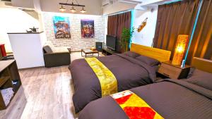 a bedroom with two beds and a living room at KIYAZA Station Sapporo 2 in Sapporo