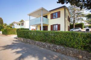 a house with a hedge in front of it at Daila Apartments in Novigrad Istria