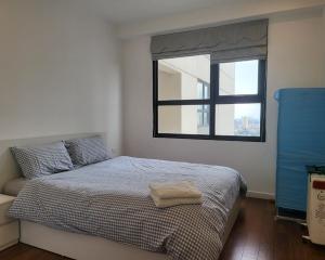 um quarto com uma cama com uma janela em 2 BR Vinhomes Dcapitale next to Charmvit Tower em Hanói