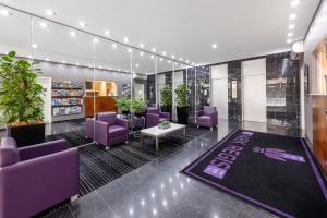 a lobby with purple chairs and a rug at Park Regis Concierge Apartments in Sydney