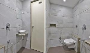 a white bathroom with a toilet and a sink at FabHotel Prime Legend in Surat