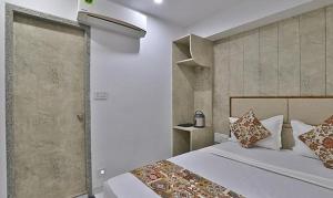 ein Schlafzimmer mit einem großen weißen Bett mit Kissen in der Unterkunft FabHotel Prime Legend in Surat