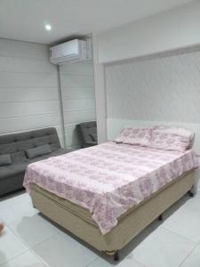 ein Schlafzimmer mit einem Bett mit einer rosa Decke in der Unterkunft O melhor de Maceió, Edf Time, Ponta verde. in Maceió
